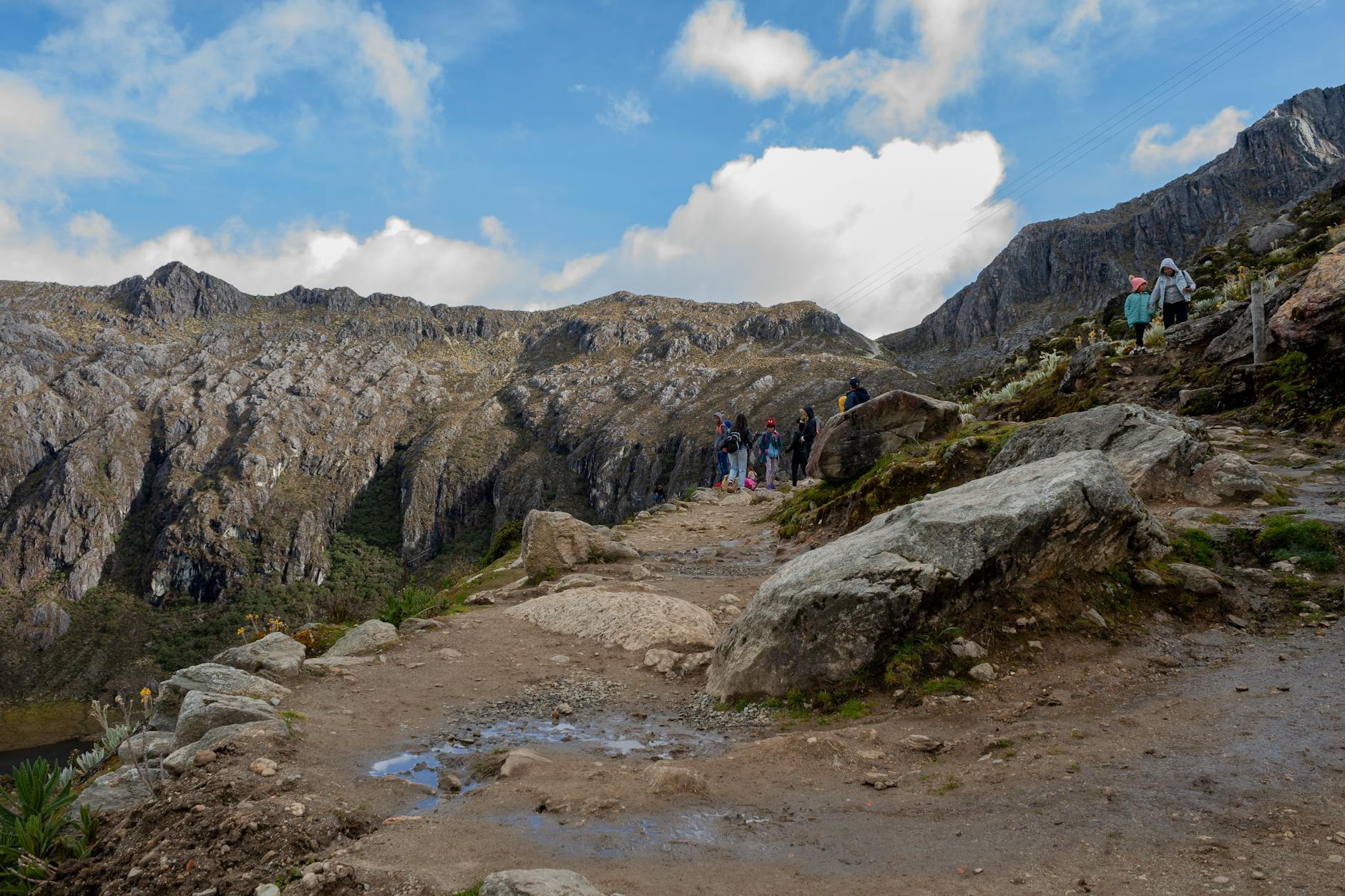 Turyści na górskim szlaku z widokiem na skaliste szczyty