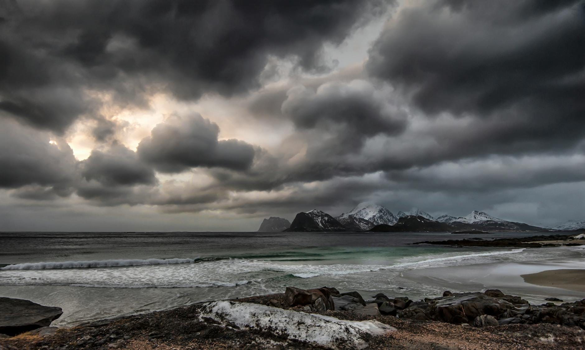 Burzowe niebo nad ośnieżonym, skalistym wybrzeżem Norwegii