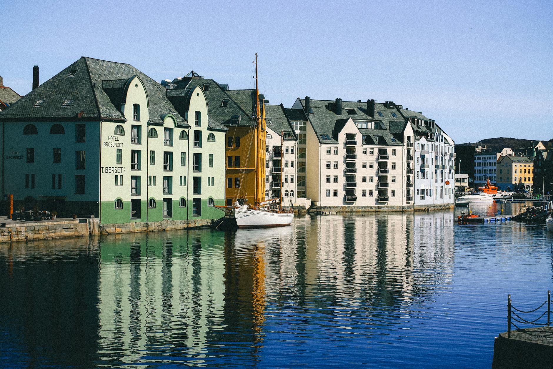 Kolorowe kamienice nad wodą w norweskim porcie odbijające się w tafli