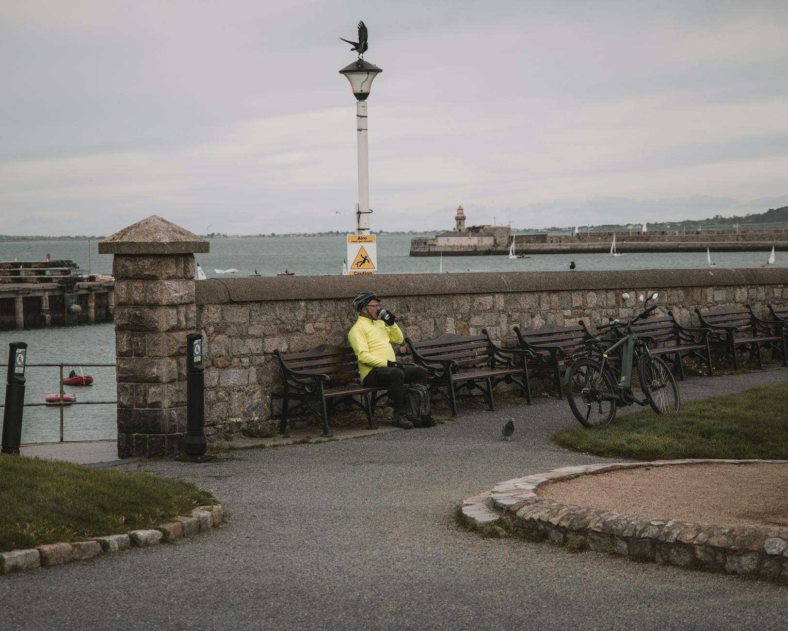 Rowerzysta odpoczywa na ławce nad morzem w nadmorskim porcie