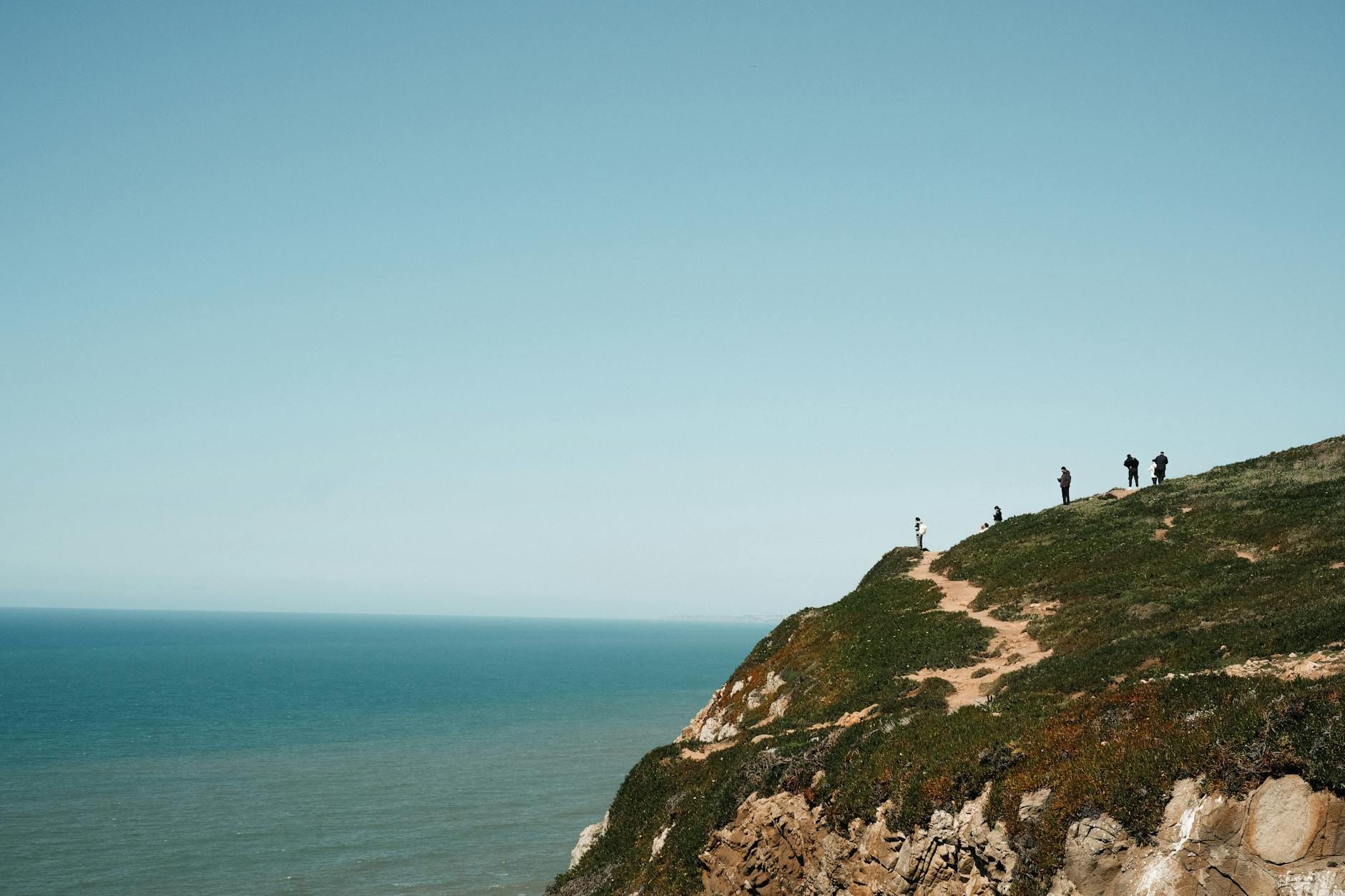 Turyści na klifie podziwiają morze podczas wędrówki w Kristiansand