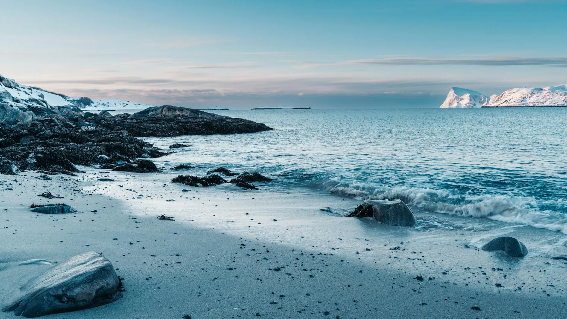 Zimowa, ośnieżona plaża nad morzem w Norwegii