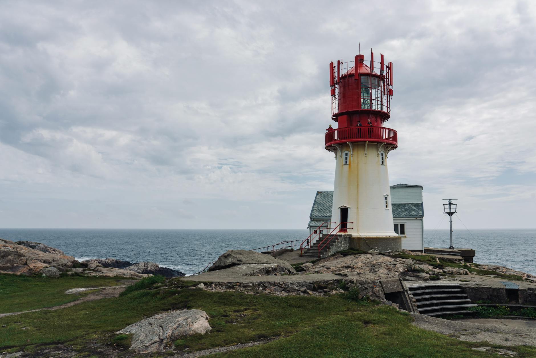 Latarnia morska Lindesnes na skalistym wybrzeżu pod pochmurnym niebem