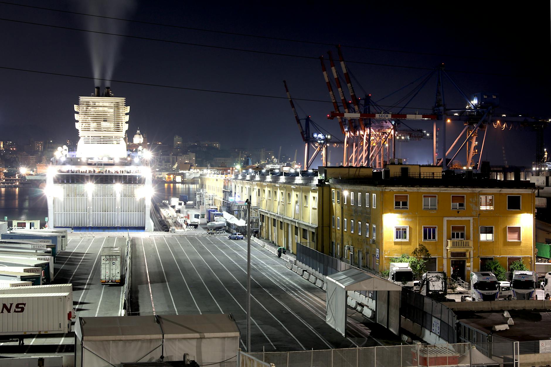 Nocny port z oświetlonym promem i dźwigami w dokach