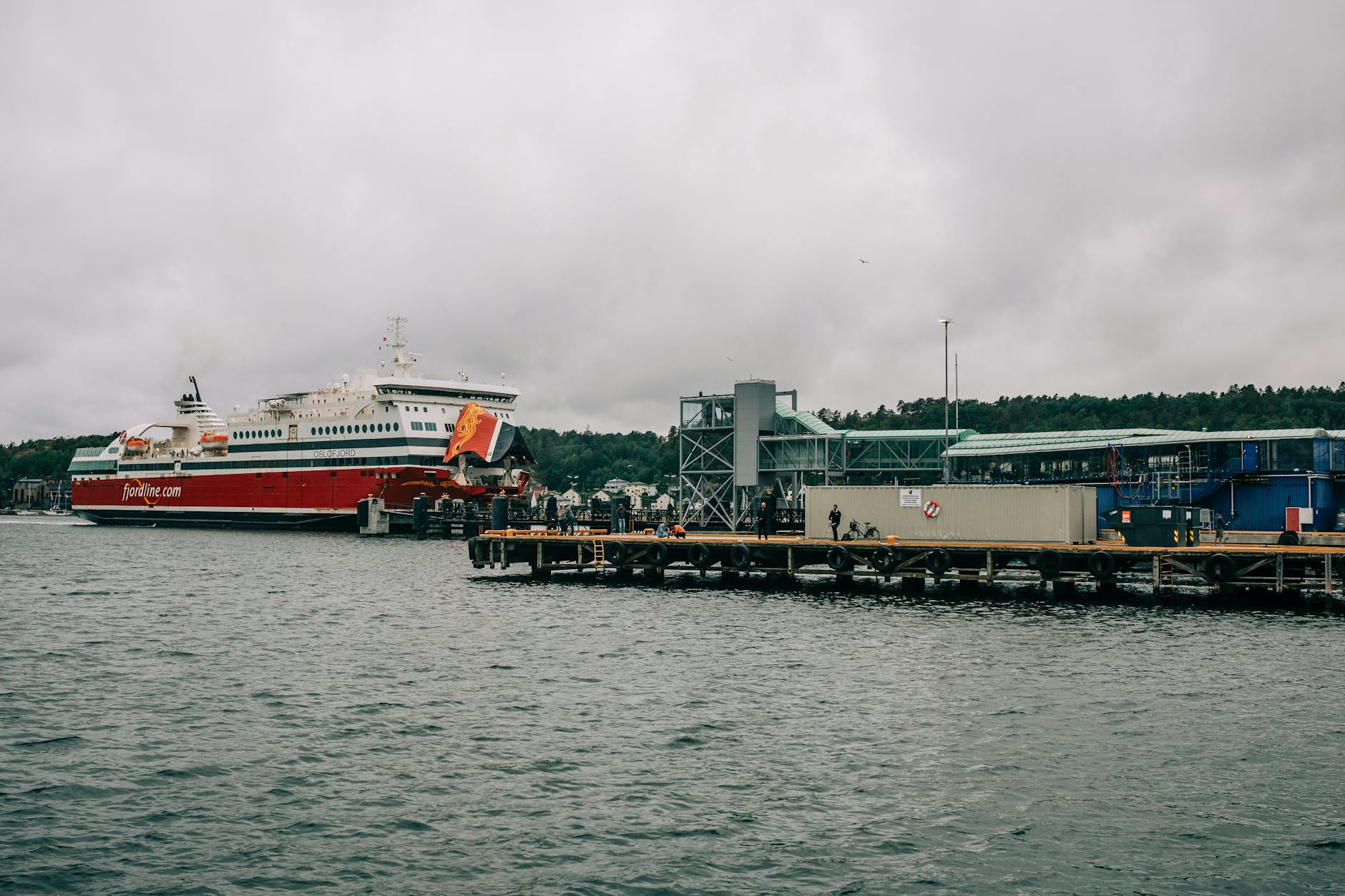 Prom Fjordline zacumowany w norweskim porcie przy pochmurnym niebie