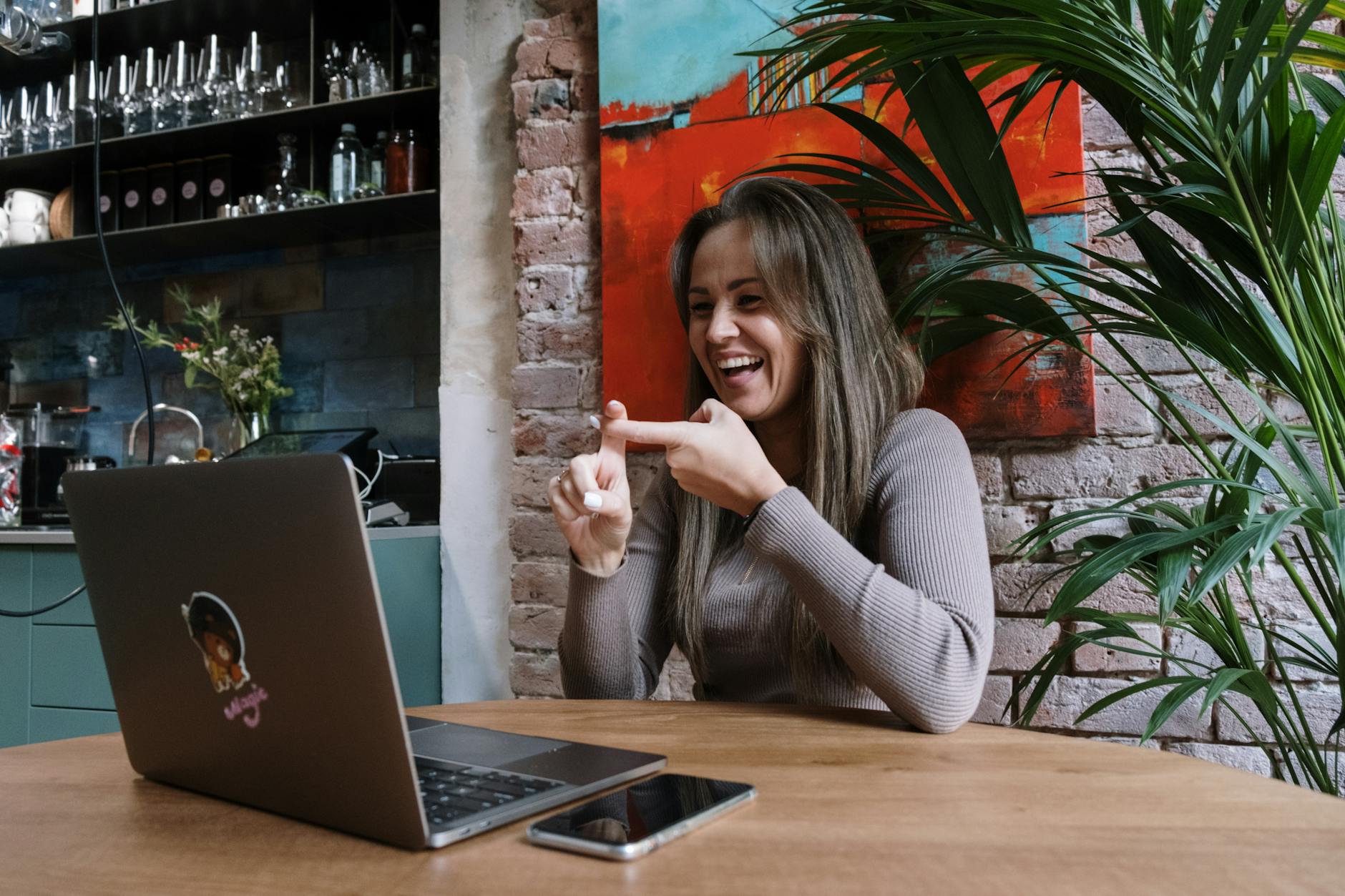 Uśmiechnięta kobieta uczy się języka migowego na lekcji online