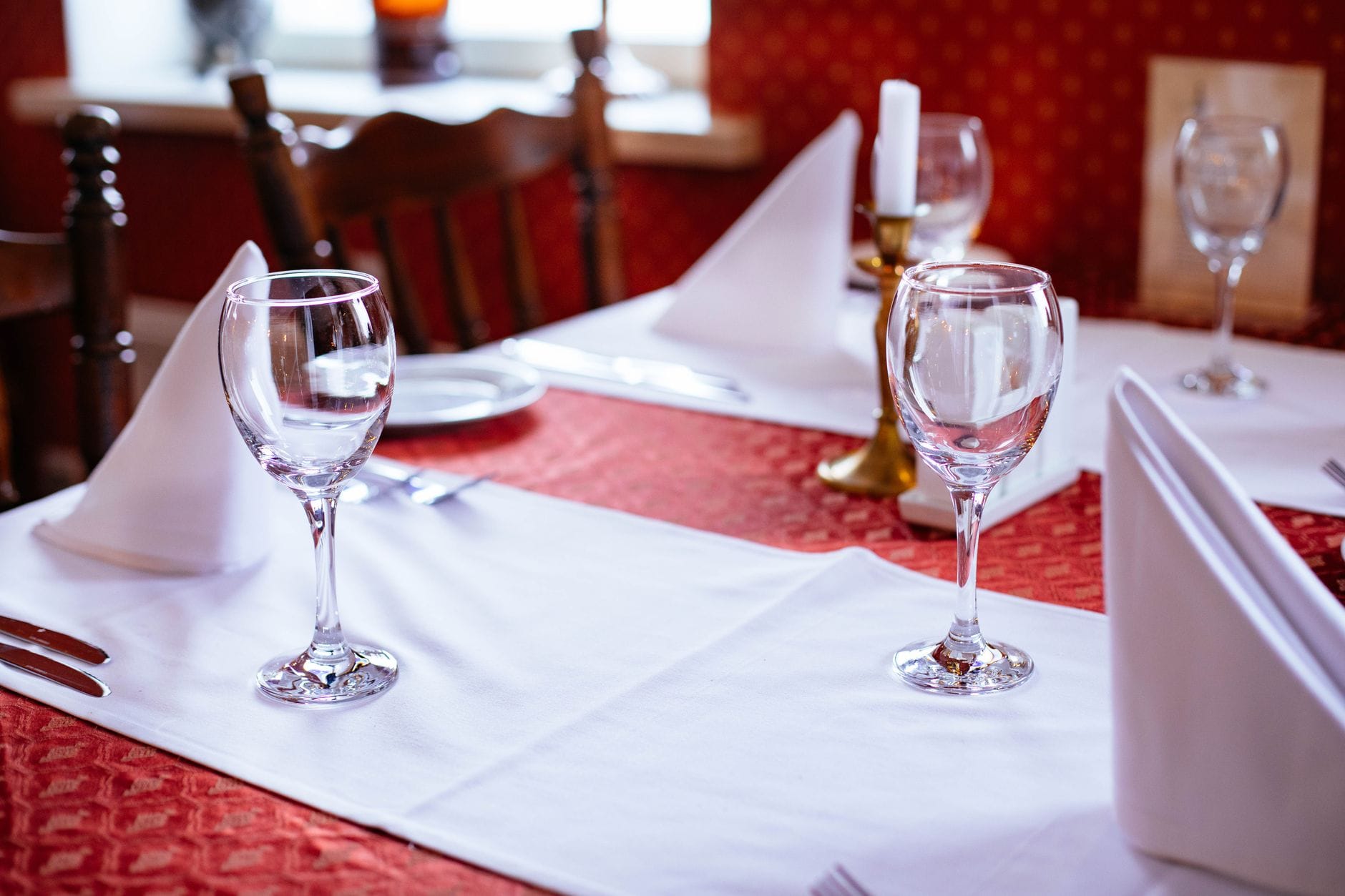 Elegancko nakryty stolik z winem i świecami w przytulnej restauracji