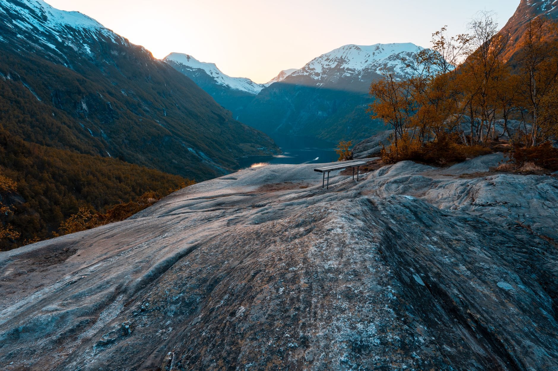 Szlak na Kongens utsikt: panorama miasta i fiordu w 30 minut Jesienny zachód słońca nad fiordem Geiranger i ośnieżonymi górami