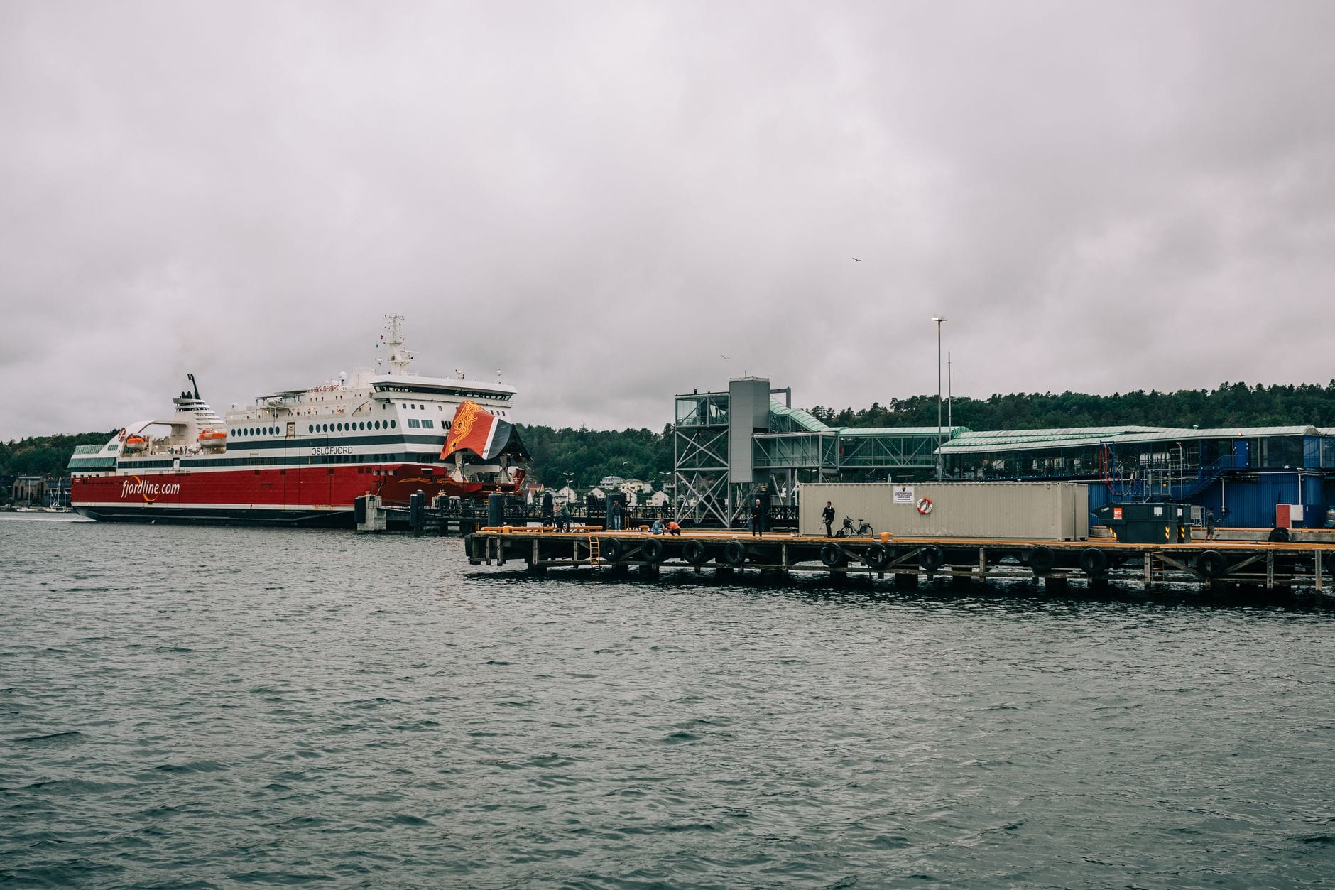 Prom Fjordline zacumowany w norweskim porcie przy pochmurnym niebie
