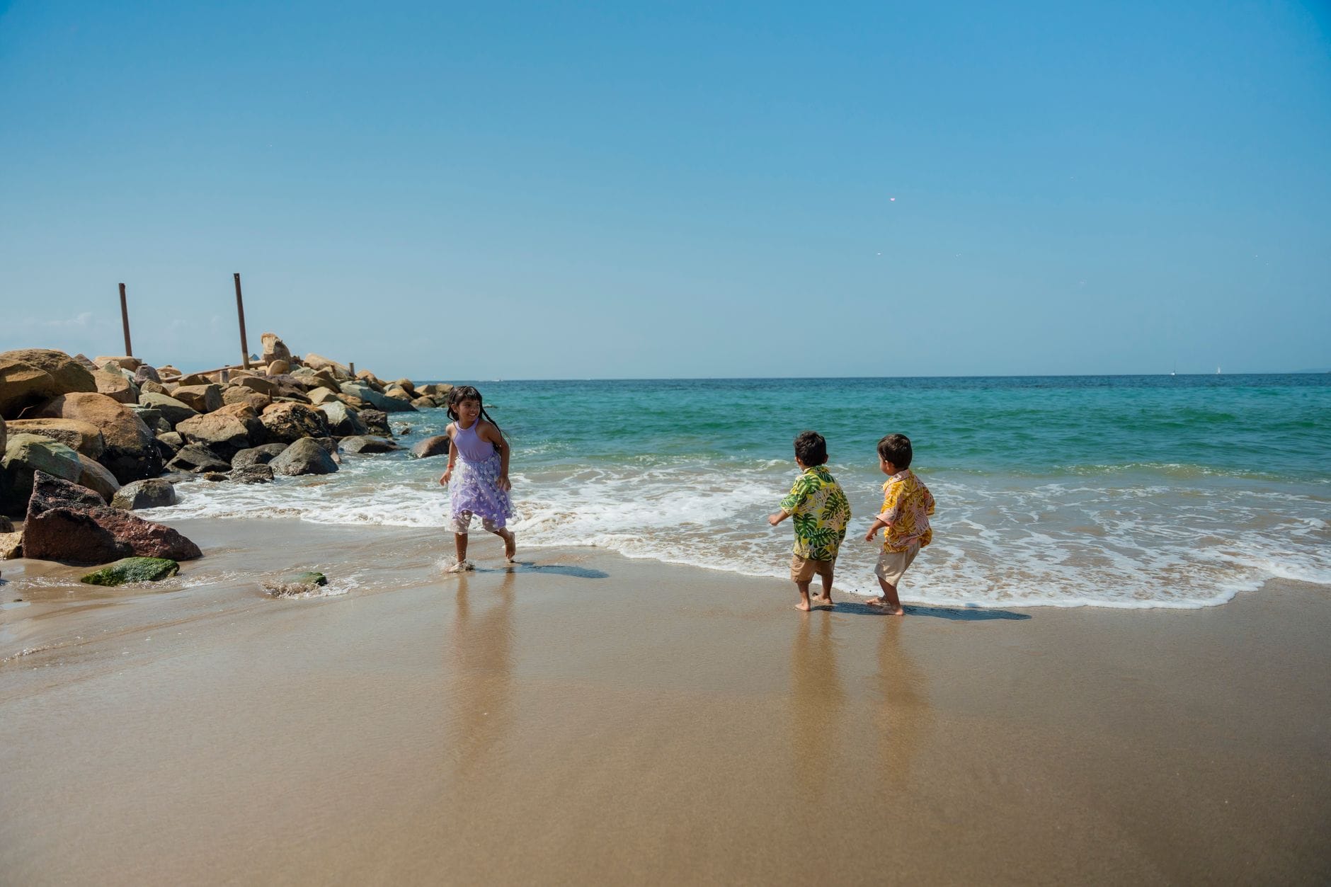 Rodzinne plaże w Sørlandet: piasek, łagodne zejścia i place zabaw Dzieci bawiące się na słonecznej, piaszczystej plaży nad morzem
