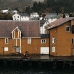 Żółte drewniane domy nad spokojnym nabrzeżem w Kristiansand